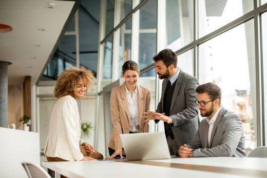 Small office staff at laptop smiling 