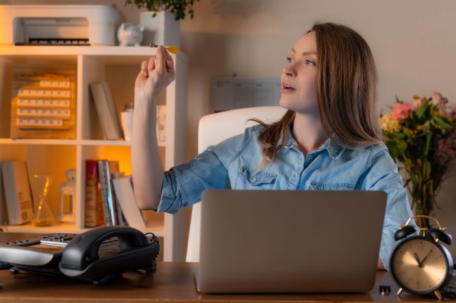 Lady at laptop looking to the side with a dart